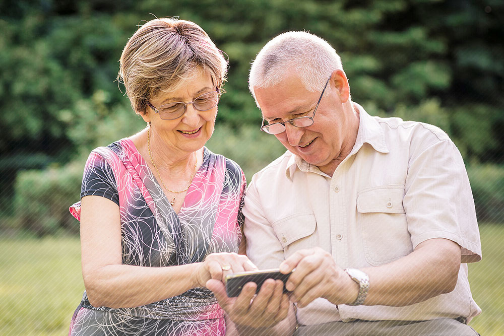 Rentner Ehepaar guckt auf Smartphone